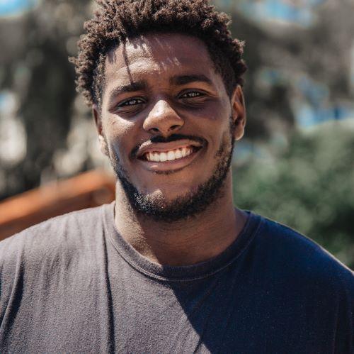 a profile picture of a man looking at the camera and smiling