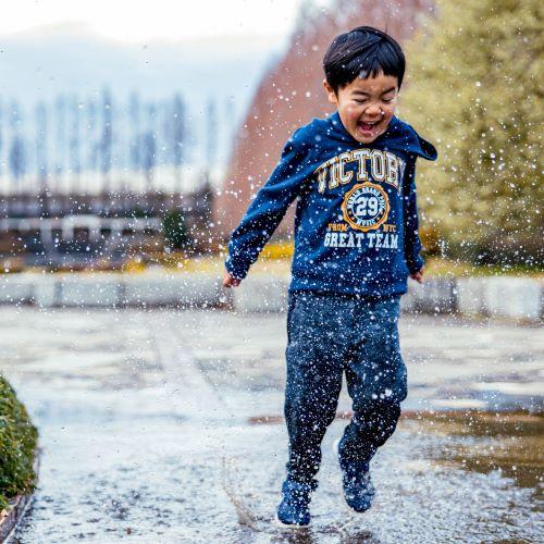 a little boy splashing through water