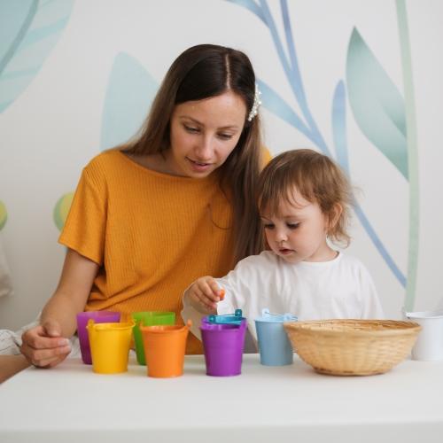 a young mum and her daughter sorting through drinking cups