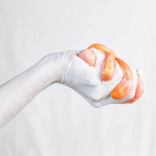 a greyscale hand squeezing orange slime