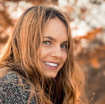 a profile picture of a brunette woman looking at the camera and smiling